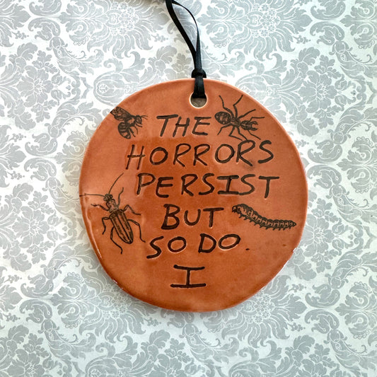 Handmade ceramic The Horrors Persist But So Do I wall hanging in red orange