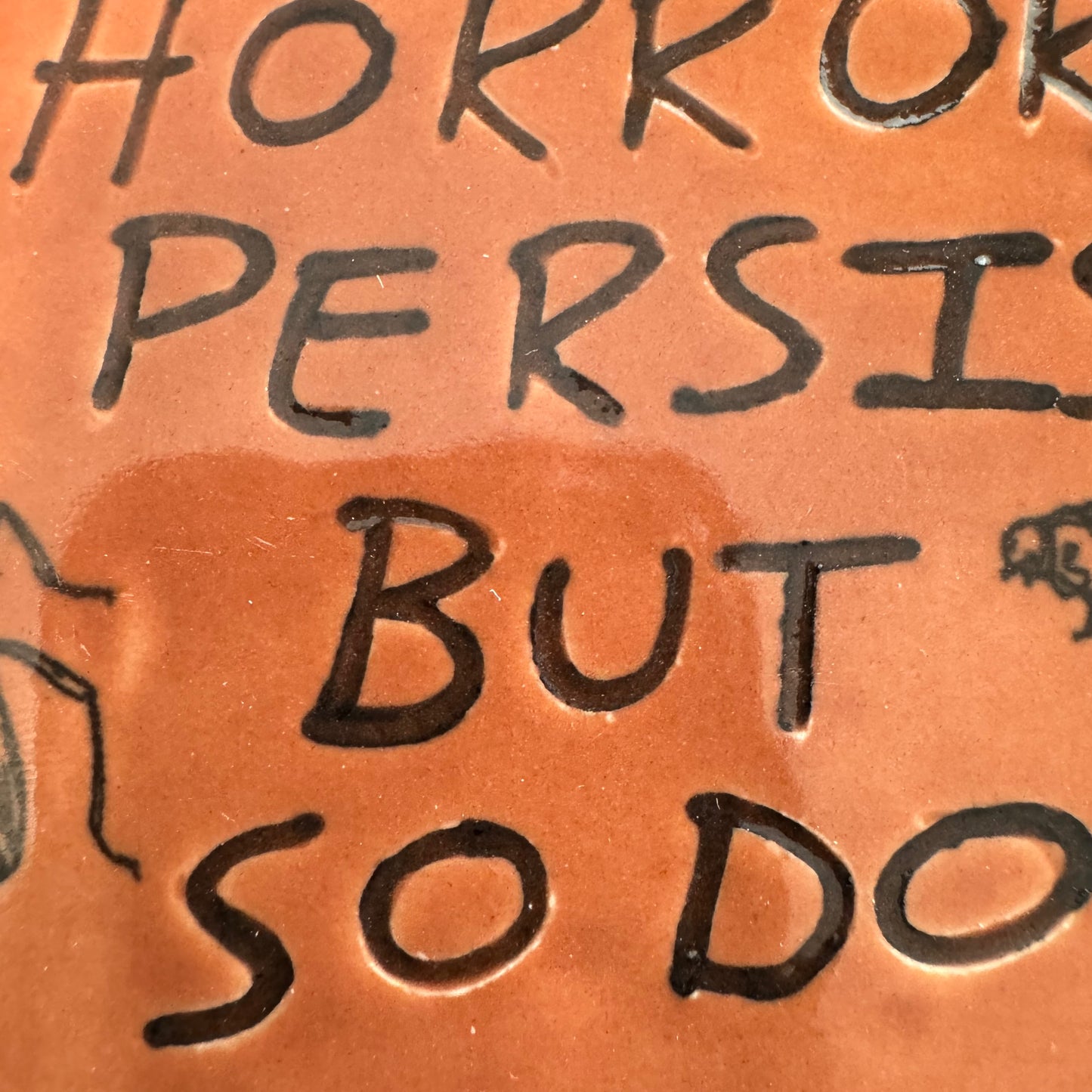 Handmade ceramic The Horrors Persist But So Do I wall hanging in red orange