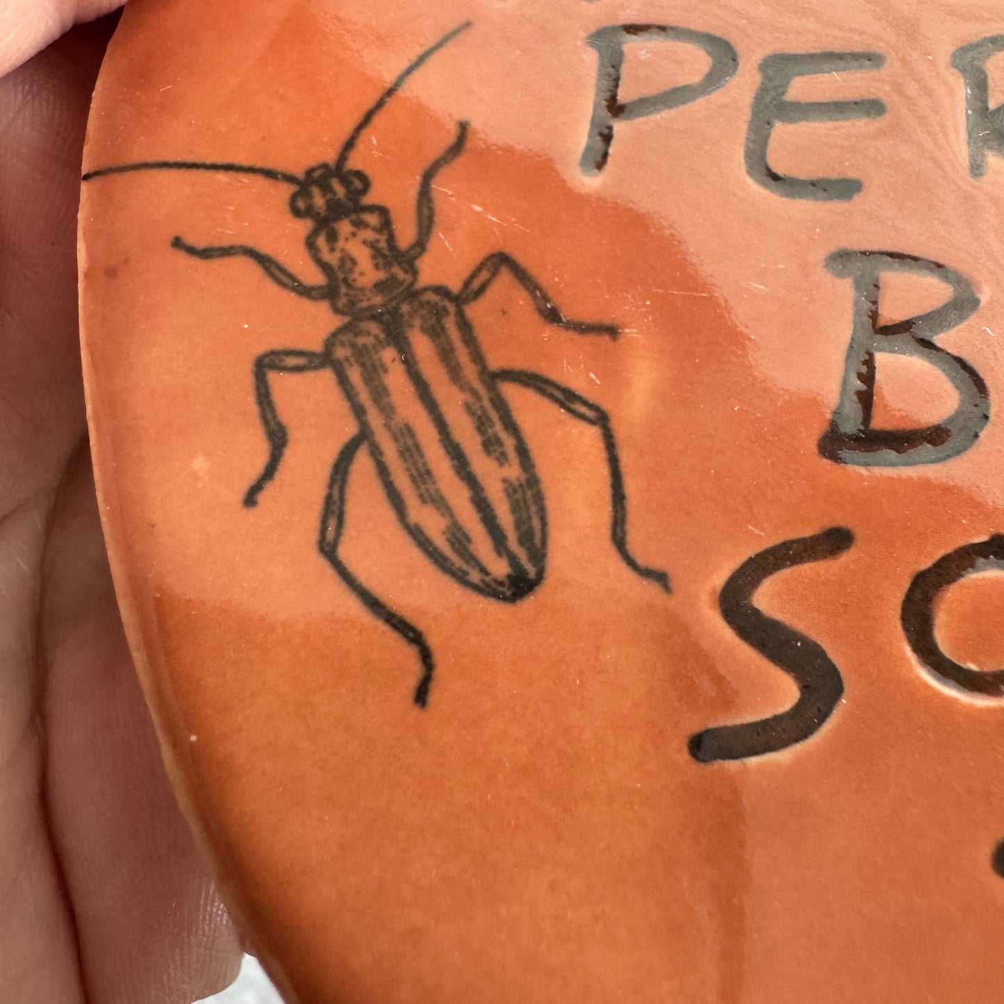 Handmade ceramic The Horrors Persist But So Do I wall hanging in red orange